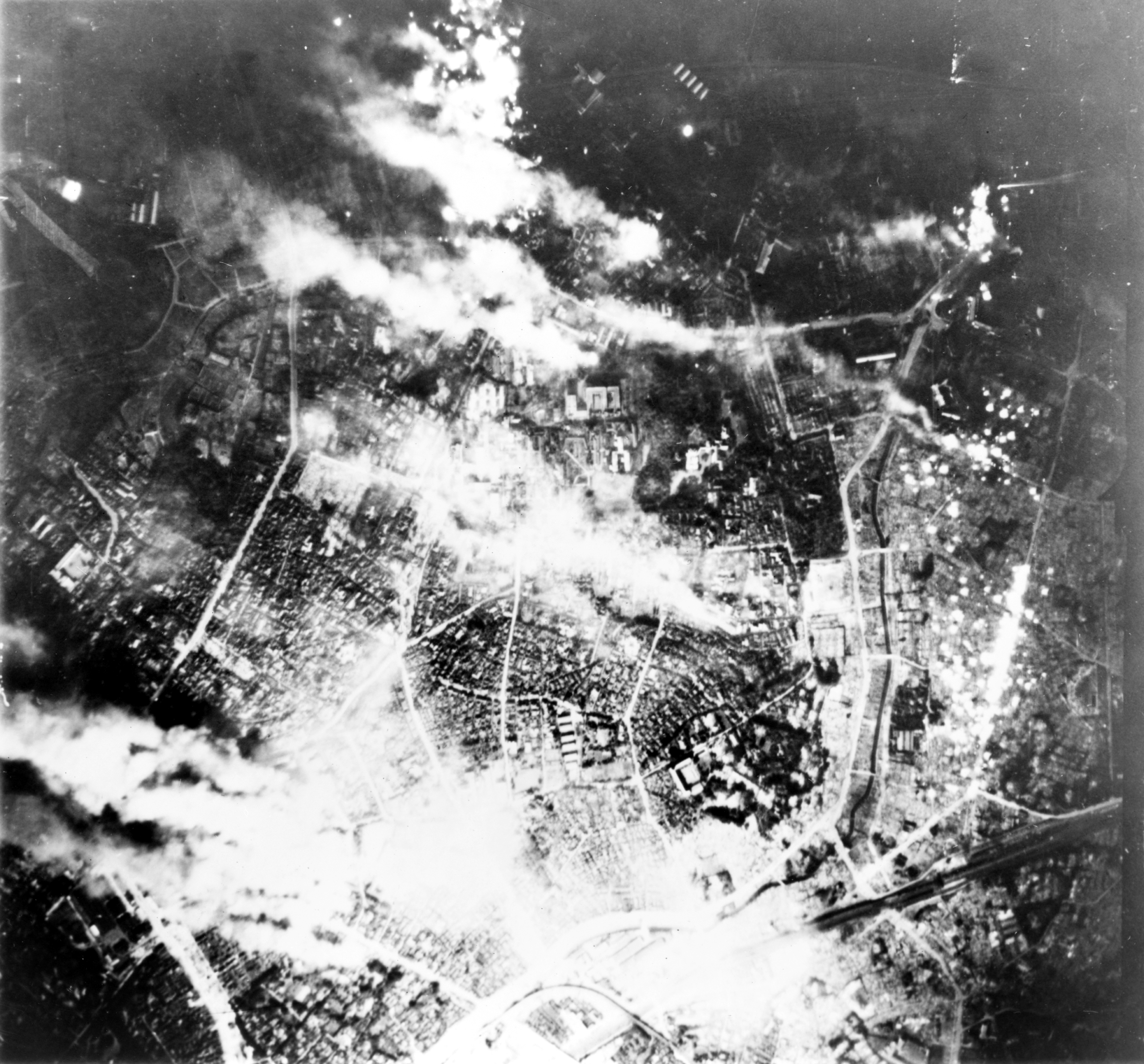 Black-and-white U.S. Army Air Forces photograph of Tokyo burning during a 1945 incendiary raid.